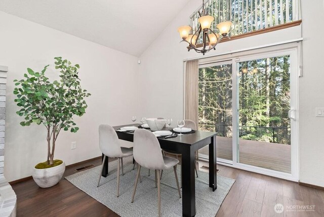 dining room with visible vents, baseboards, a chandelier, lofted ceiling, and wood finished floors