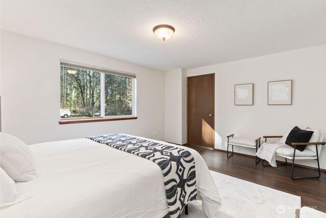 bedroom featuring a textured ceiling and wood finished floors