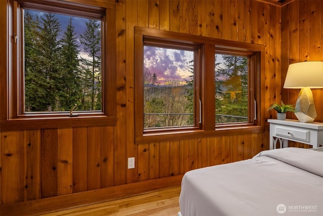 bedroom with wooden walls and wood finished floors
