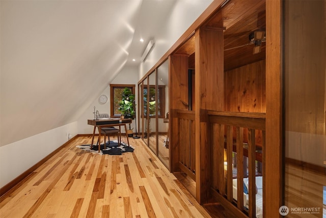 additional living space featuring baseboards, lofted ceiling, and wood finished floors