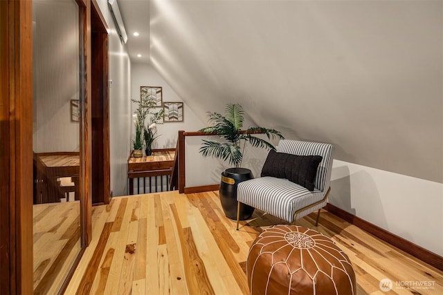 living area featuring baseboards, lofted ceiling, light wood finished floors, and recessed lighting