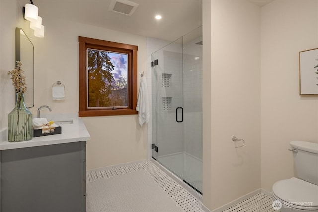 full bathroom with vanity, toilet, baseboards, a stall shower, and visible vents