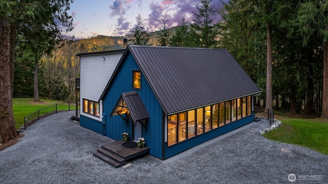 view of front of home featuring metal roof, a front yard, and a standing seam roof