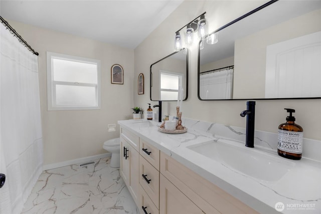 bathroom featuring marble finish floor, toilet, baseboards, and a sink