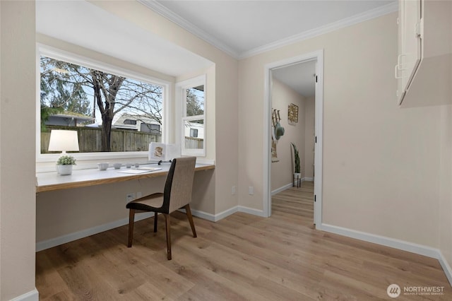 office featuring baseboards, light wood-style floors, built in desk, and crown molding