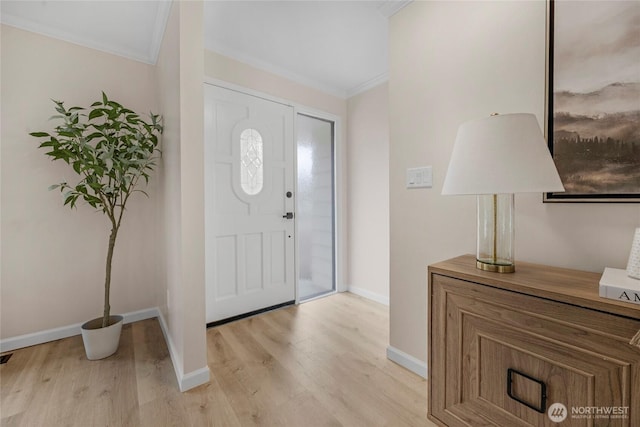 foyer entrance with baseboards, crown molding, and light wood-style floors