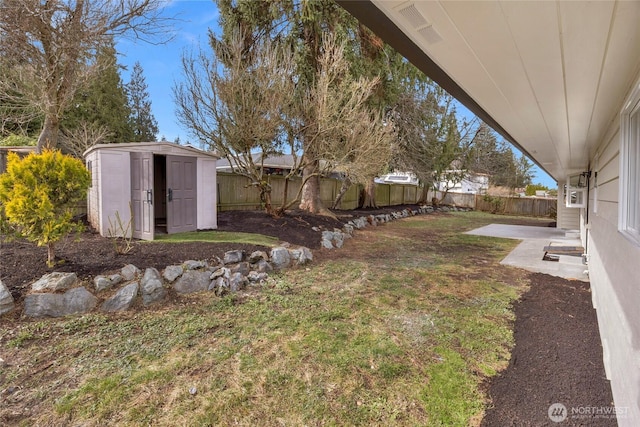 view of yard featuring an outdoor structure, a patio area, a fenced backyard, and a shed