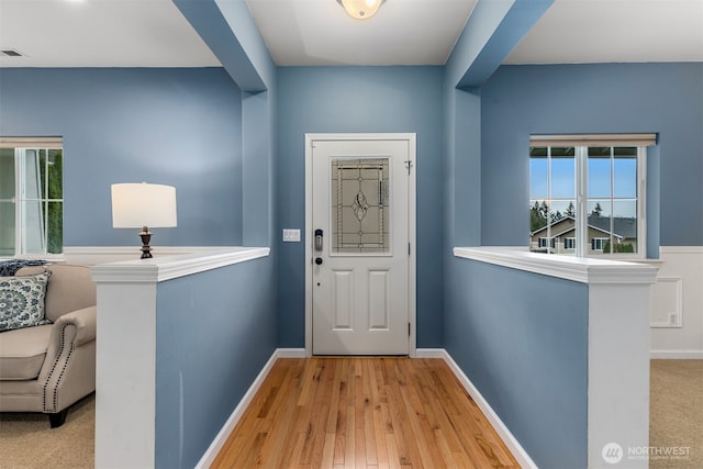 entryway with visible vents, baseboards, and wood finished floors