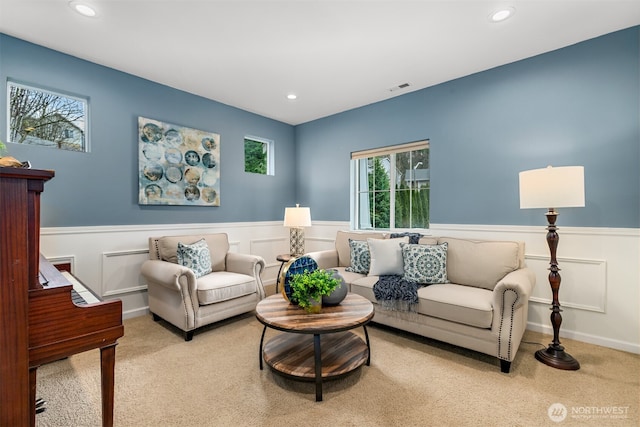 living room with recessed lighting, visible vents, light carpet, and wainscoting