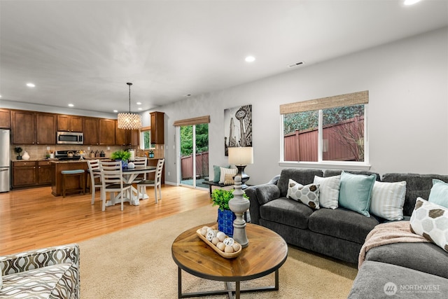 living area with visible vents, recessed lighting, and light wood-type flooring