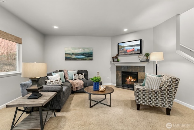 living room featuring a tiled fireplace, carpet flooring, and baseboards