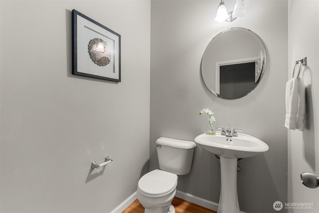 bathroom featuring toilet, wood finished floors, and baseboards