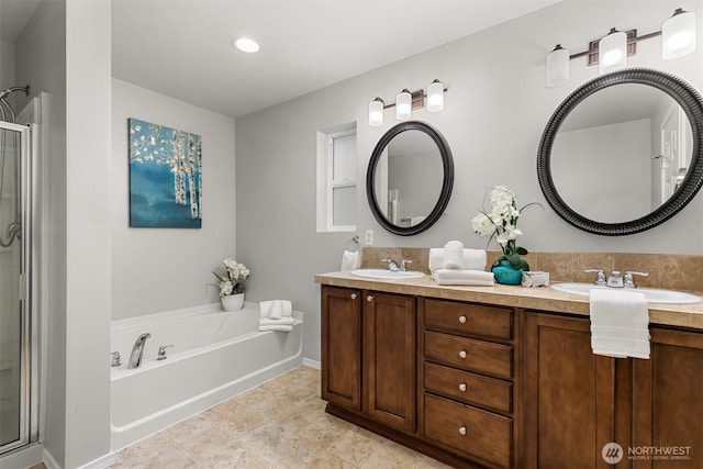 full bathroom featuring double vanity, a shower stall, and a sink