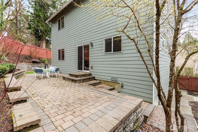 rear view of property featuring crawl space, a patio area, and fence