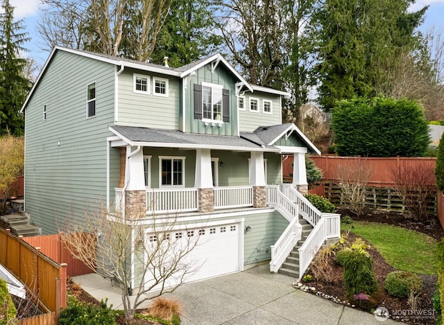 craftsman-style house featuring fence, an attached garage, stairs, stone siding, and board and batten siding