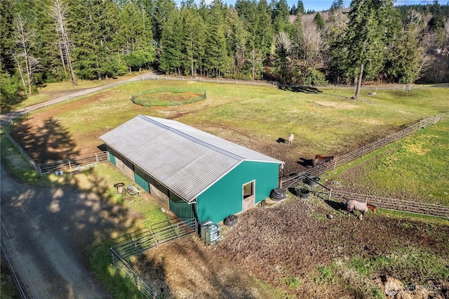 birds eye view of property featuring a rural view and a wooded view