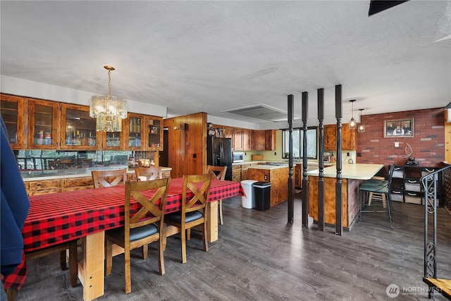 dining space with an inviting chandelier, dark wood-style flooring, and a textured ceiling