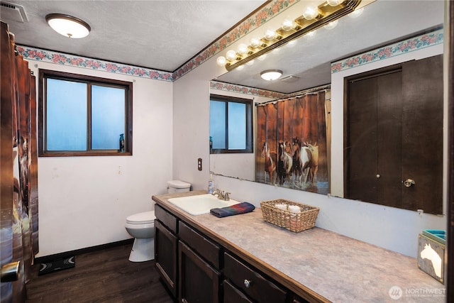 full bath with visible vents, toilet, wood finished floors, baseboards, and vanity