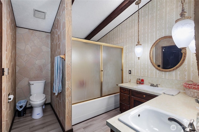 bathroom featuring toilet, wood finished floors, wallpapered walls, bath / shower combo with glass door, and vanity