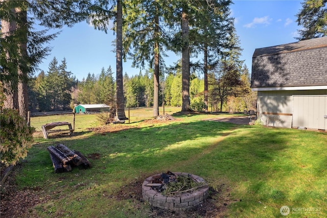 view of yard with a fire pit and fence