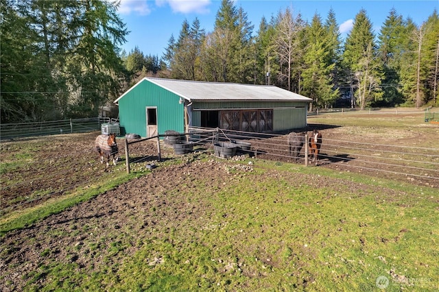 view of front of property featuring an exterior structure, metal roof, and an outdoor structure