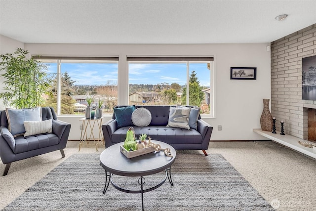 carpeted living area featuring plenty of natural light, a fireplace, a textured ceiling, and baseboards