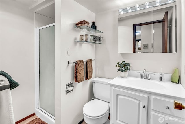 full bathroom featuring a stall shower, toilet, and vanity