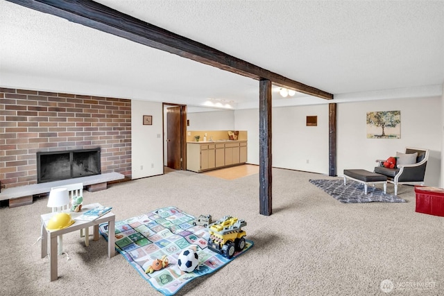 carpeted living room with beam ceiling, a brick fireplace, and a textured ceiling