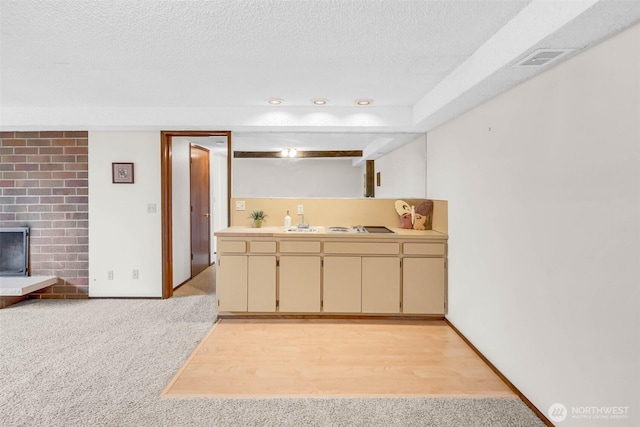 bathroom featuring visible vents, a textured ceiling, wood finished floors, a fireplace, and baseboards