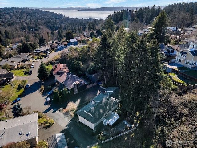 birds eye view of property with a view of trees and a water view