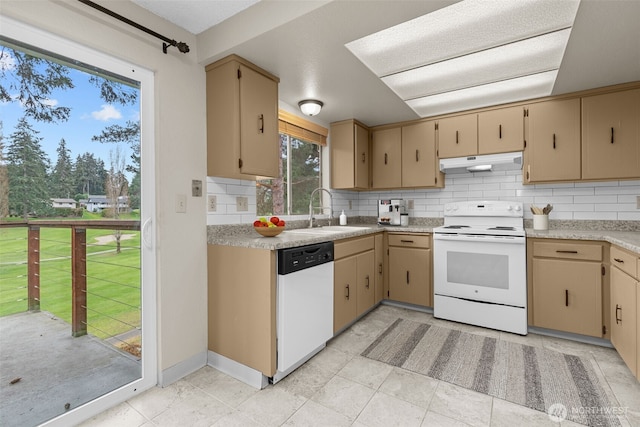 kitchen featuring tasteful backsplash, under cabinet range hood, light countertops, white appliances, and a sink