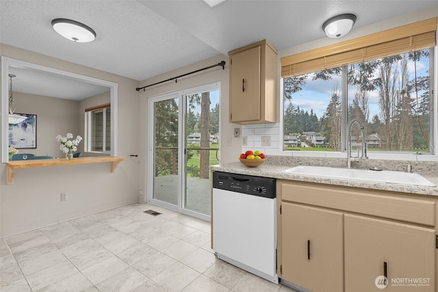 kitchen featuring a sink, visible vents, dishwasher, and light countertops