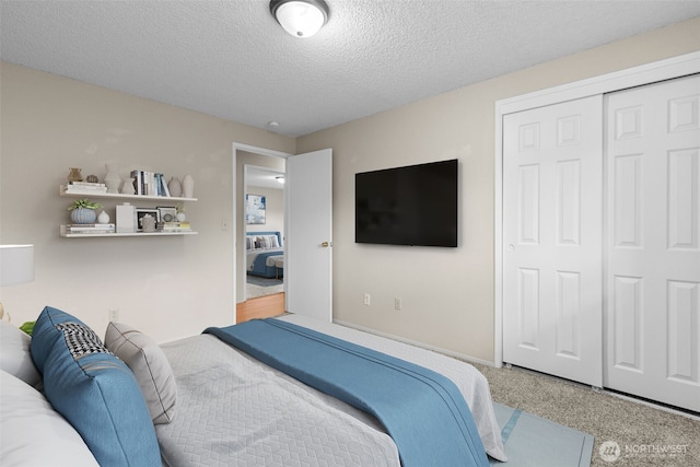 carpeted bedroom with a closet and a textured ceiling