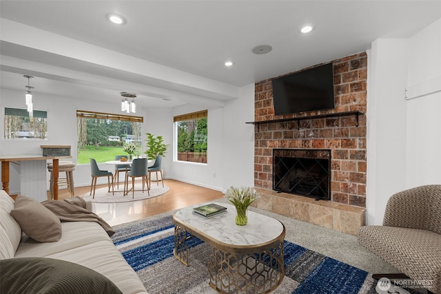 living area featuring wood finished floors, recessed lighting, a fireplace, and baseboards