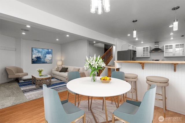 dining area featuring recessed lighting, light wood-type flooring, and stairs