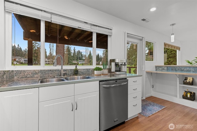 kitchen featuring light wood-style flooring, a sink, stainless steel dishwasher, white cabinetry, and recessed lighting