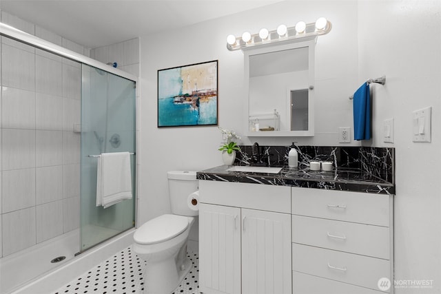 full bath featuring tile patterned floors, toilet, a stall shower, and vanity