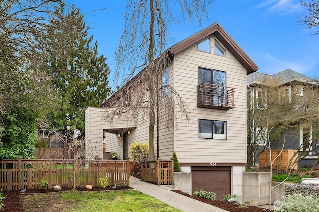 view of front of house featuring an attached garage and fence