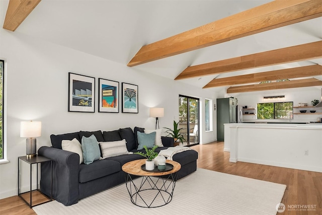 living area with vaulted ceiling with beams and wood finished floors