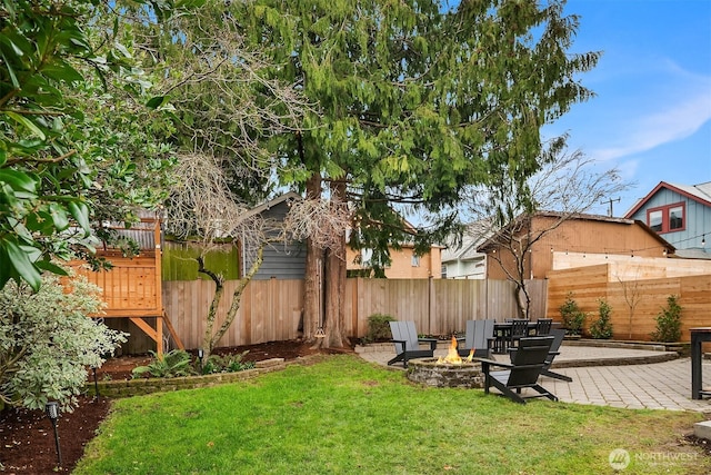 view of yard with a fenced backyard, a fire pit, and a patio