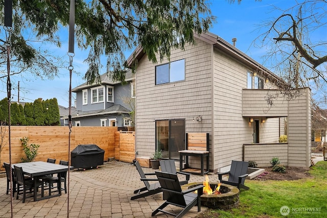 back of property featuring a patio, a fire pit, and fence