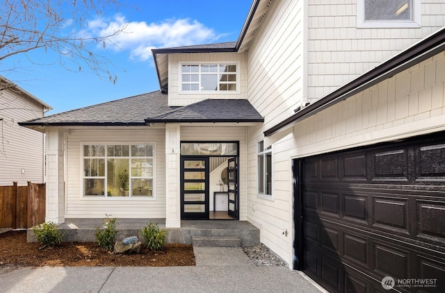 property entrance featuring fence, a garage, and a shingled roof