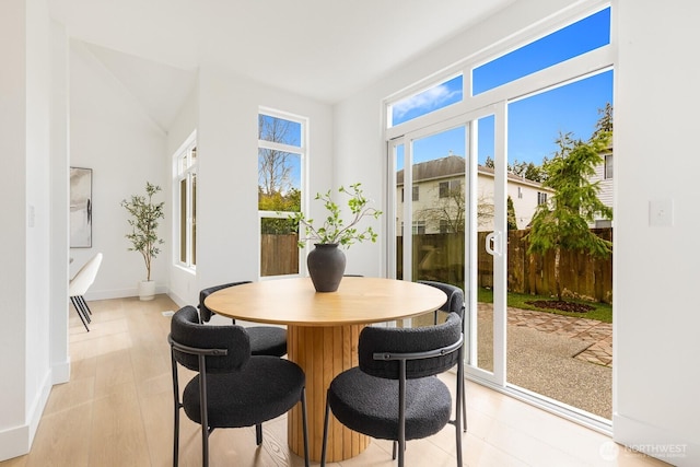 dining space with light wood-type flooring and baseboards