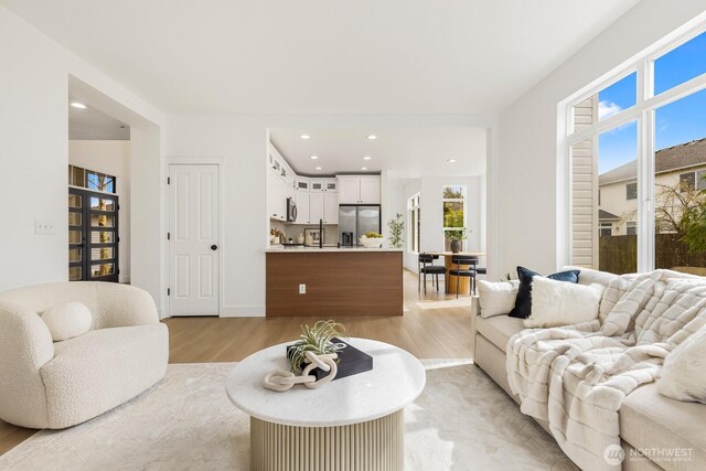 living area featuring recessed lighting and light wood-style floors