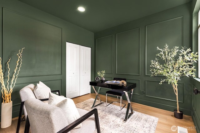 home office featuring a decorative wall, recessed lighting, visible vents, and wood finished floors