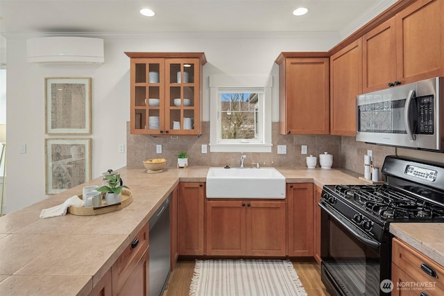 kitchen featuring a wall mounted AC, a sink, backsplash, stainless steel appliances, and light countertops