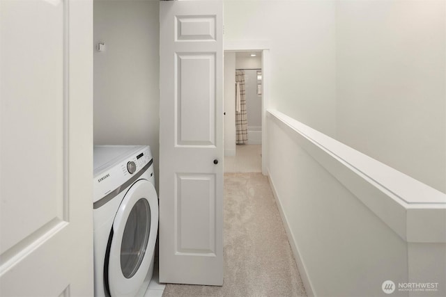 clothes washing area featuring laundry area, washer / clothes dryer, baseboards, and light carpet