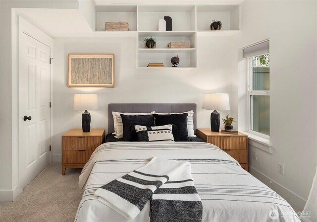 bedroom featuring light colored carpet and baseboards