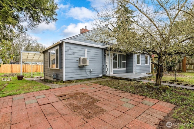 rear view of property with a patio area, fence, and a chimney