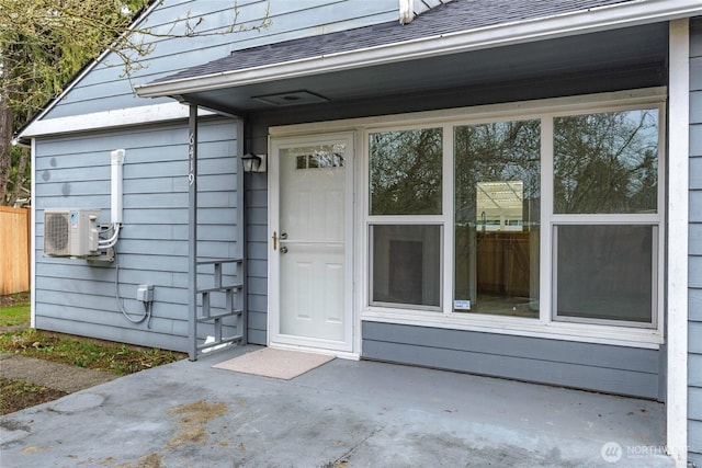 entrance to property featuring ac unit, roof with shingles, and fence